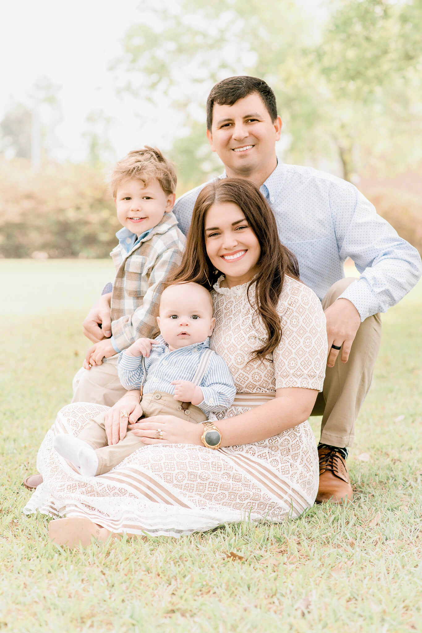A mother dresses in a neutral geometric lace maxi dress from a Baton Rouge boutique with her husband and two young boys.