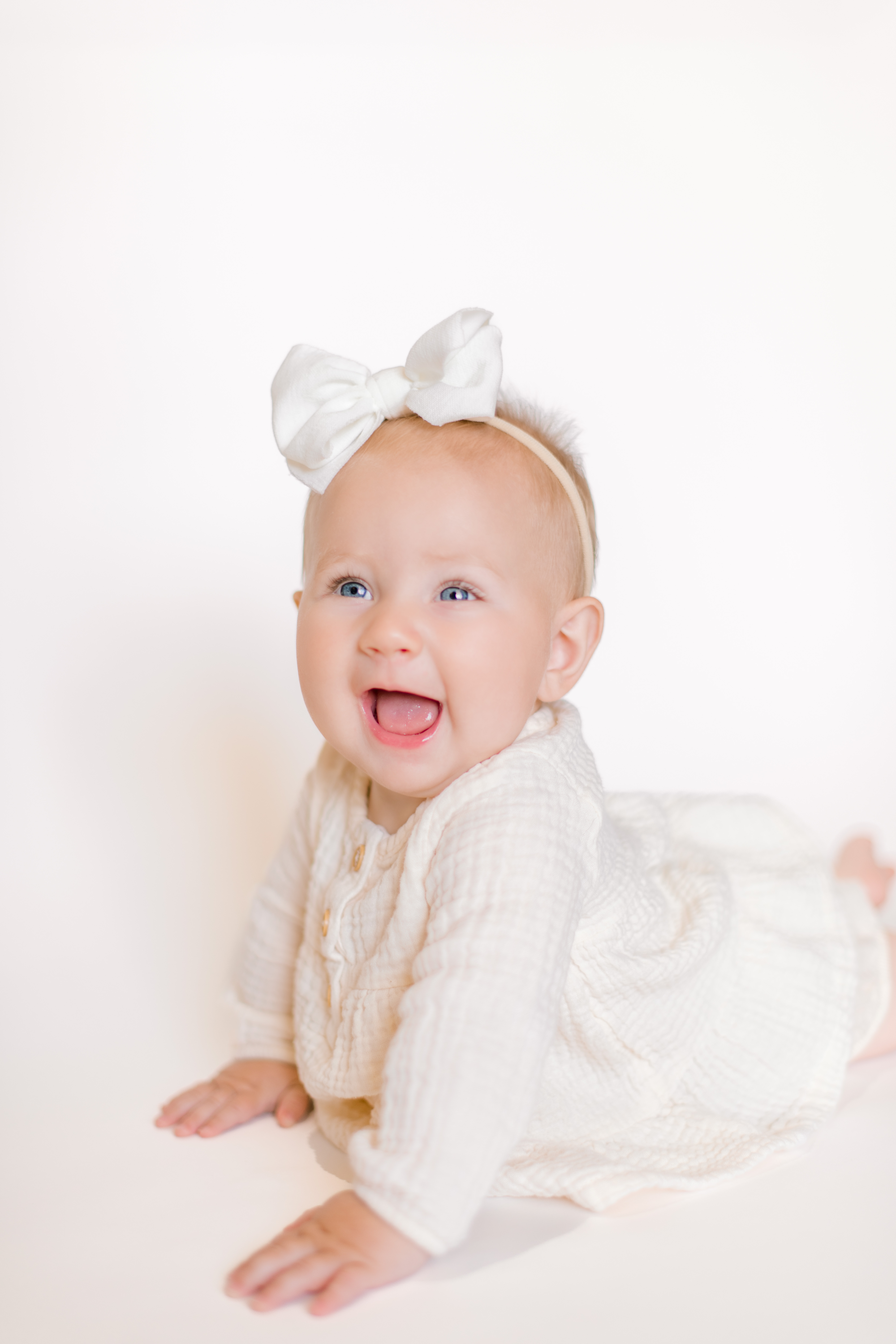 Smiling baby holds herself up for six month photos taken by Morgan with Morgan Leigh Photography.