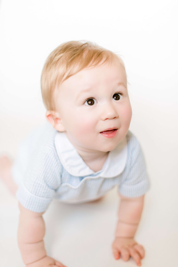 Young boy crawls during first birthday photo session with Morgan Leigh Photography.
