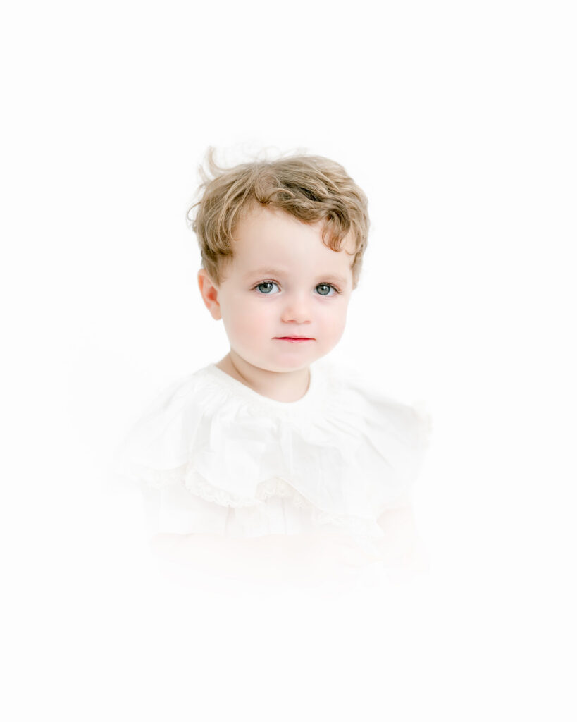 Little boy in an heirloom outfit poses beautifully for a photo session.