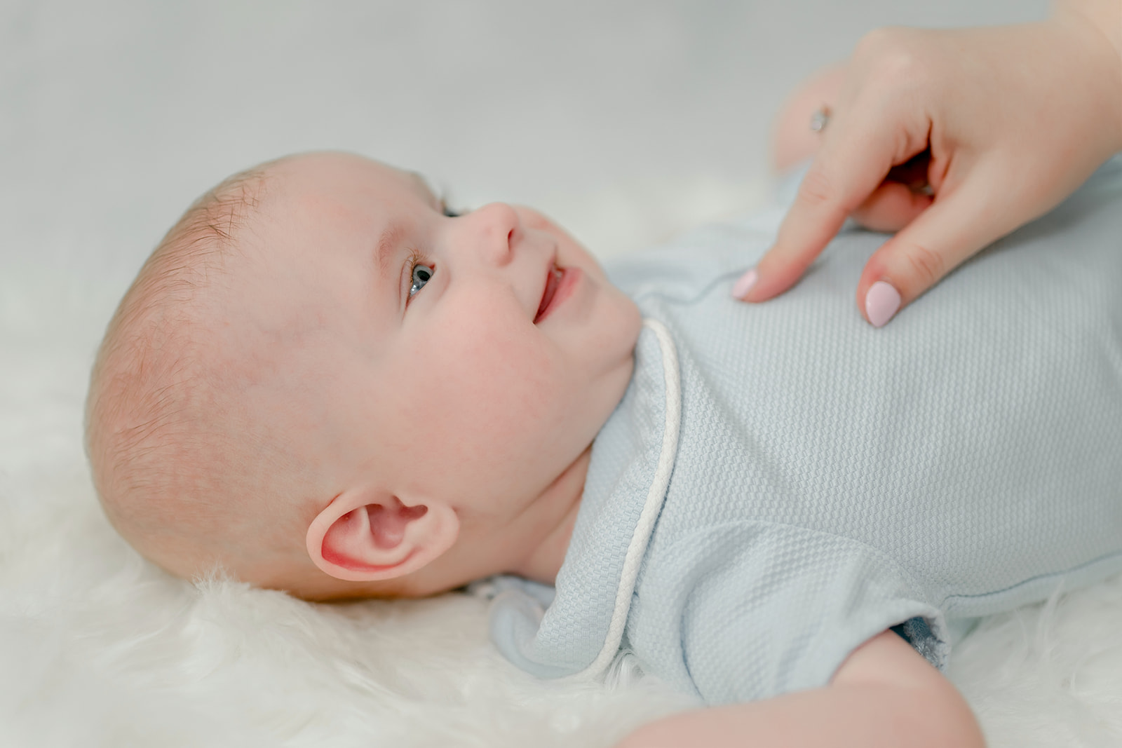 Baby wearing outfit from Baton Rouge Baby Boutique lays for photo with Morgan Leigh Photography.
