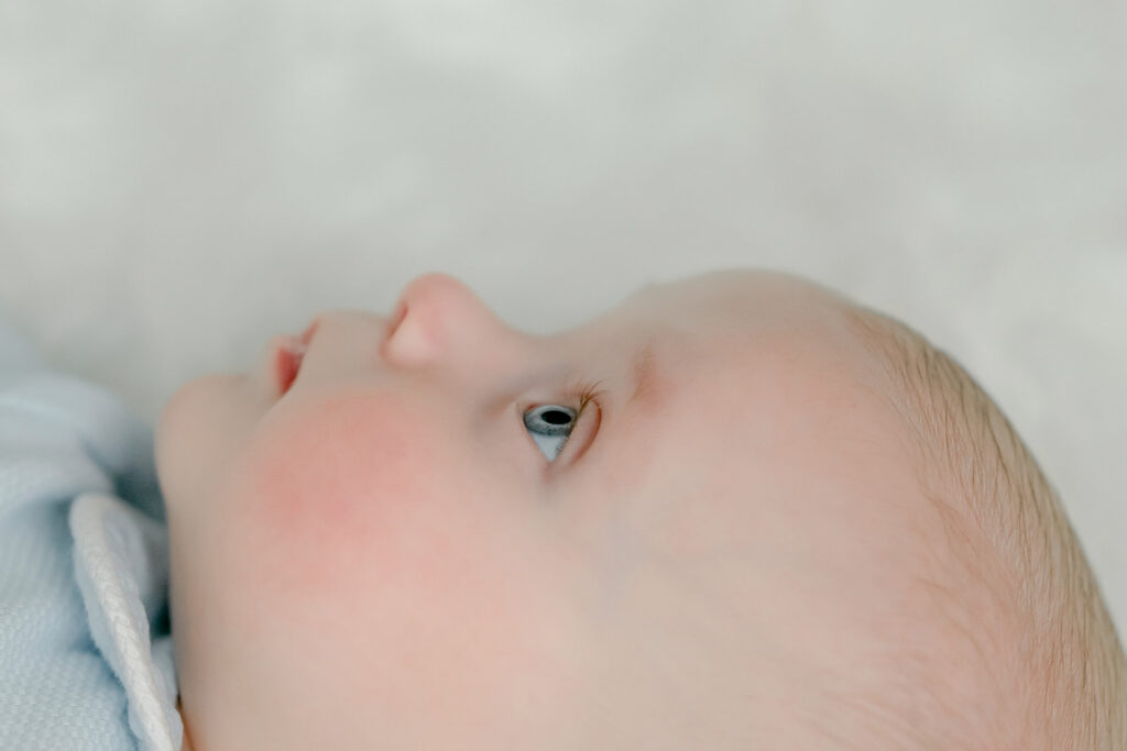 Side profile of four month old baby with blue eyes.