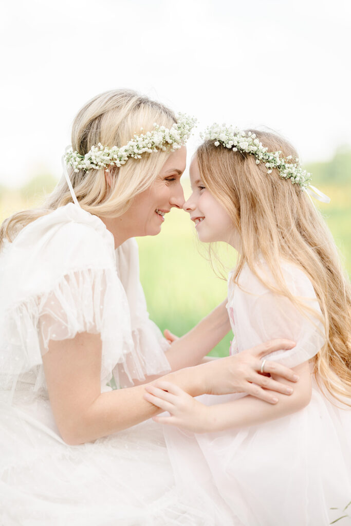 Mom and daughter share eskimo kisses in field in Baton Rouge.